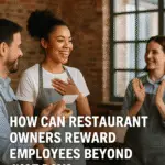 Restaurant employees celebrating recognition; a smiling woman receives a reward card from a colleague while another applauds, symbolizing employee appreciation beyond pay.